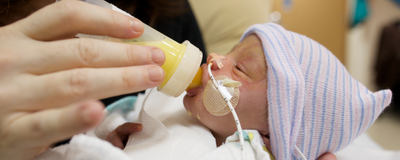 A premature infant drinking from a bottle